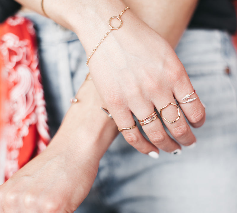 Model wears Kenda Kist Circle bracelet styled with stacked rings