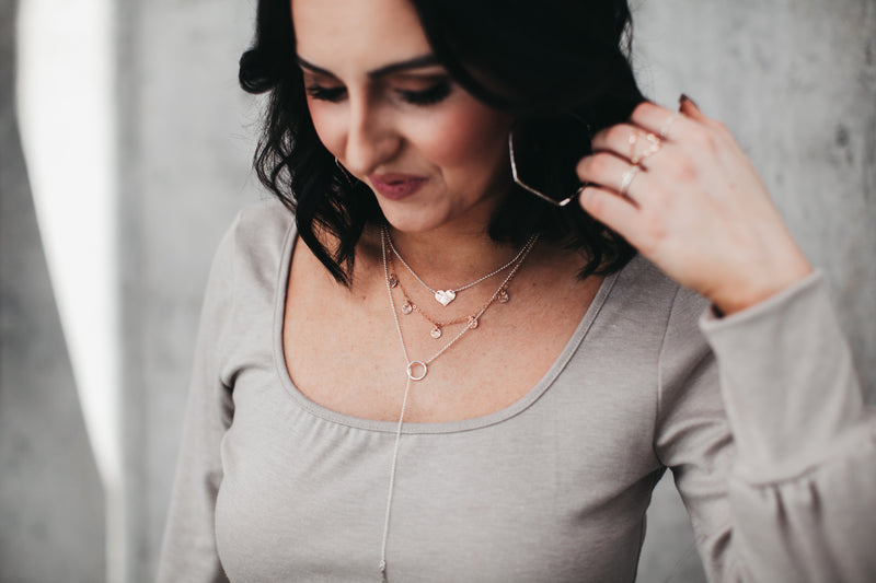Model layers the Sterling Silver heart necklace with five disc necklace and circle lariat