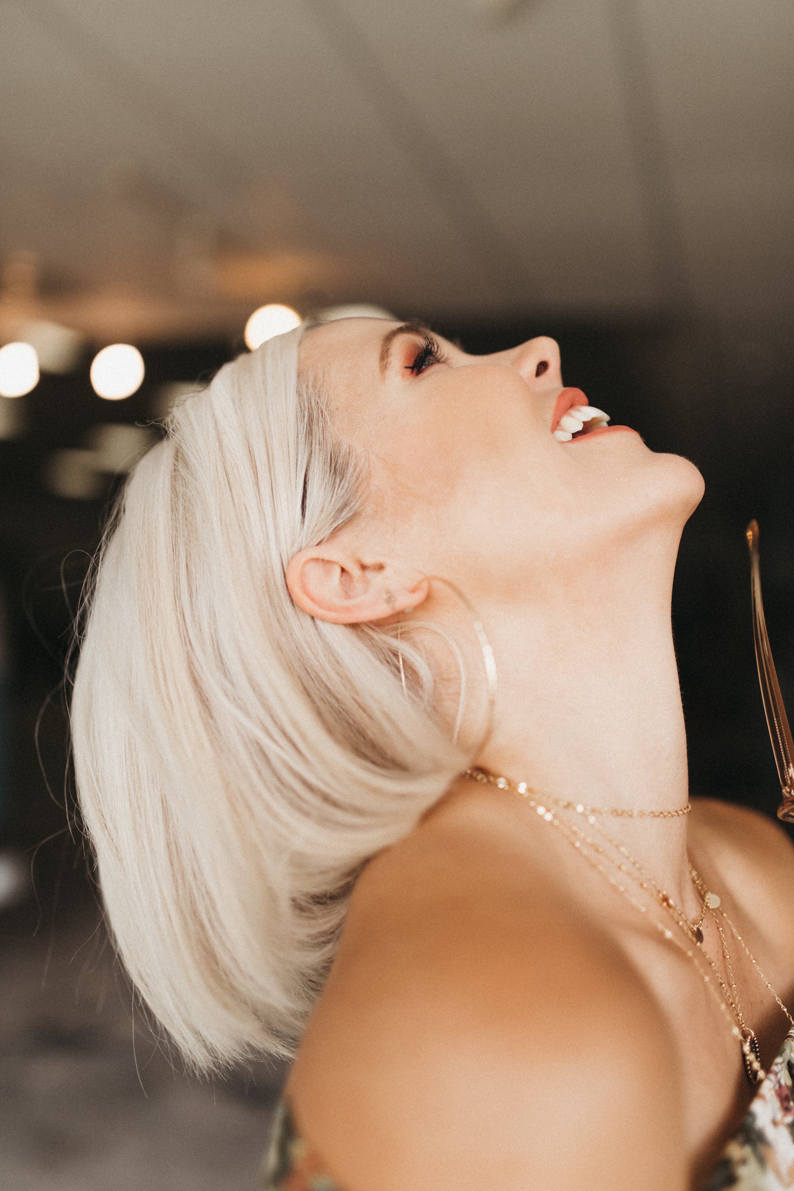 Model laughs while wearing the Kenda Kist layering chain and ashley hoops