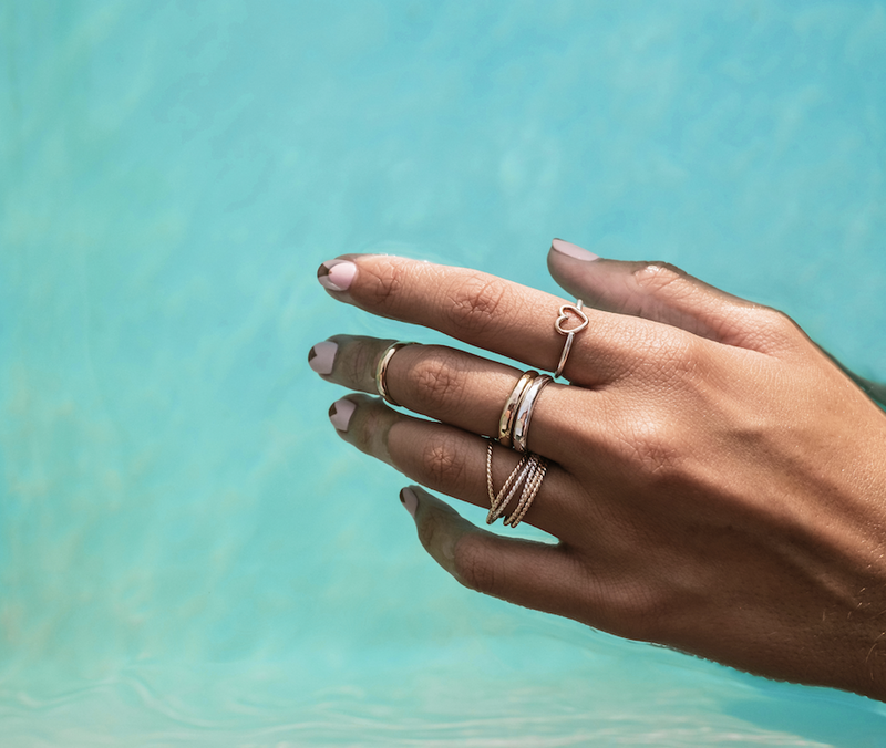 Model wears the interlocking rings with stackable band rings