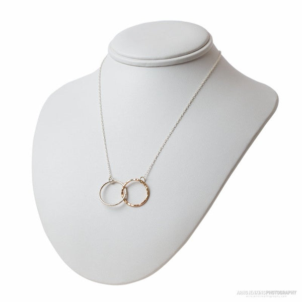 Two tone sterling silver and 14k gold filled connected circle necklace on a neck display