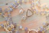 Kenda Kist Open Triangle Studs lay amongst semi-precious stones