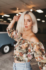 Model wears the Large Gold Hoop Earrings with a floral top and layers of gold necklaces