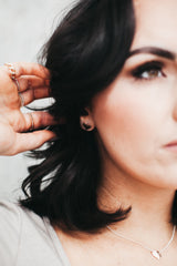 Model wears the heart stud earrings with heart pendant necklace