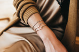 Model wears the 14k Gold Filled faceted cuff with wave cuff bracelets