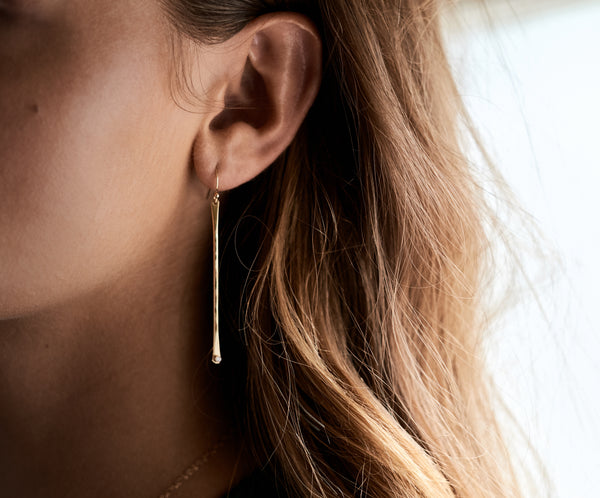Modeal wears the PuuR 14k Gold Stick Earrings with Diamond Accent