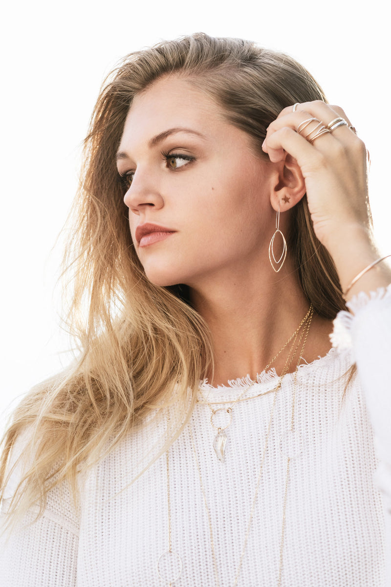 Model wears the Tiny Star Stud earrings with double marquis earrings and layered necklaces