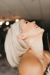Model laughs while wearing the Kenda Kist layering chain and ashley hoops