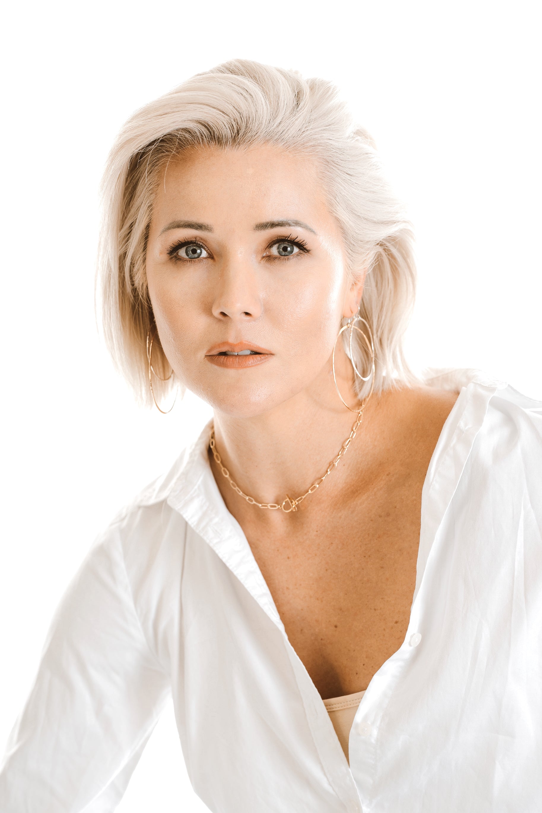 Model wears the Kenda Kist Paper Clip Chain Toggle Necklace with double hoop earrings