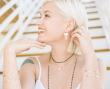 Model wears Two tone double Triangle Earrings with layered necklaces