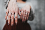 Model wears the large square ring with beaded band rings and chain ring