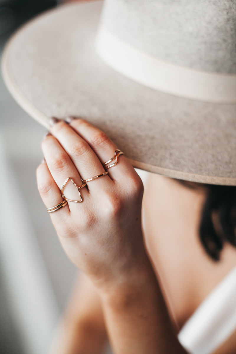 Model wears the Stackable Wave Rings with Stacklable band rings and triangle ring