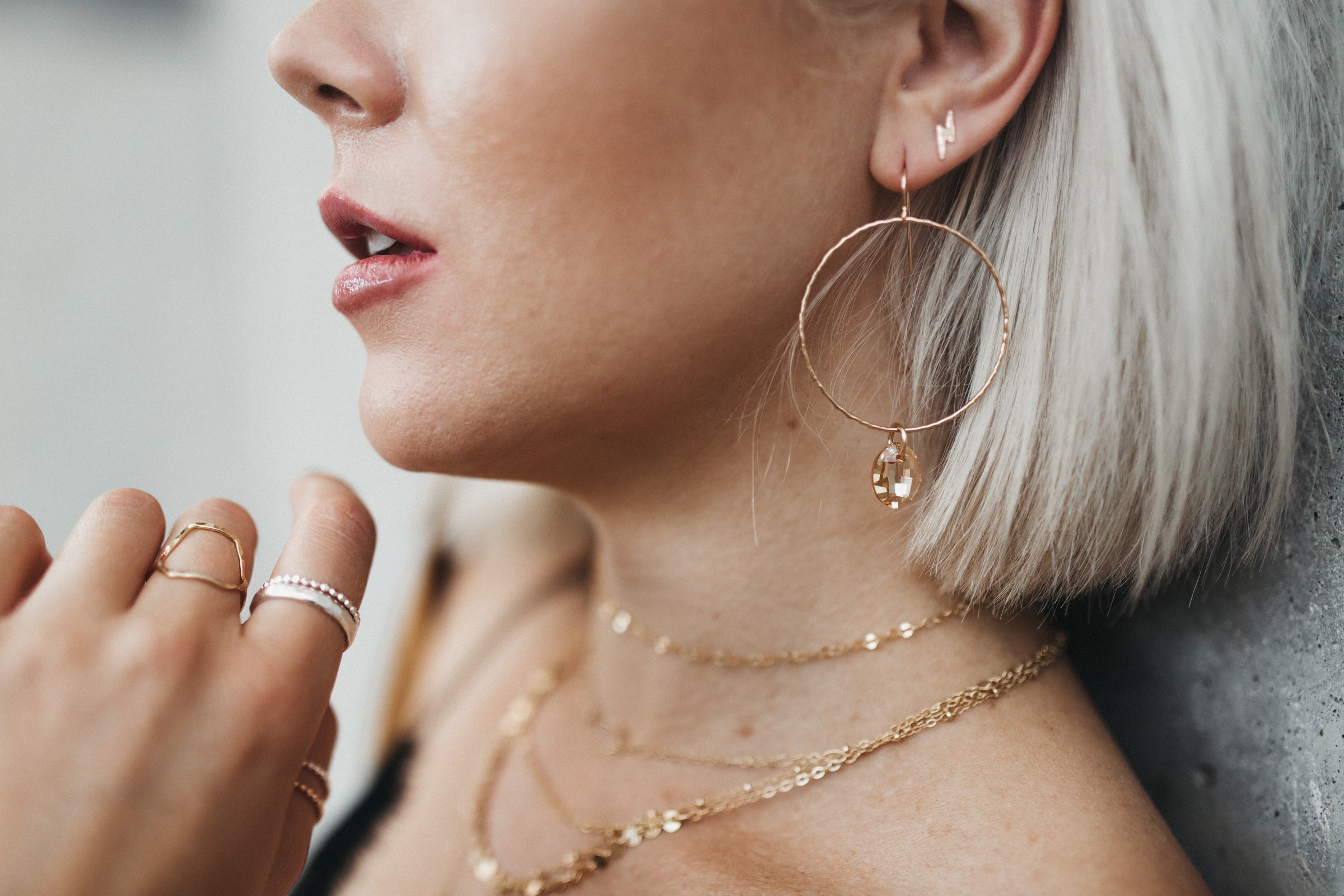 Model wears the Lightning Bolt stud earrings with the Large Circle Crystal Drop earrings