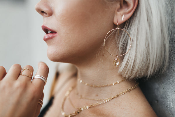 Model wears the Lightning Bolt stud earrings with the Large Circle Crystal Drop earrings