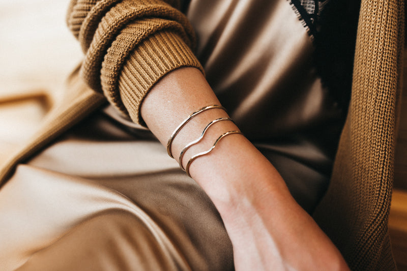 Model wears a pair of Kenda Kist wave cuffs with a faceted cuff